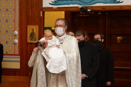 Fr Theophan processes with baby Luca, followed by the godparents and parents